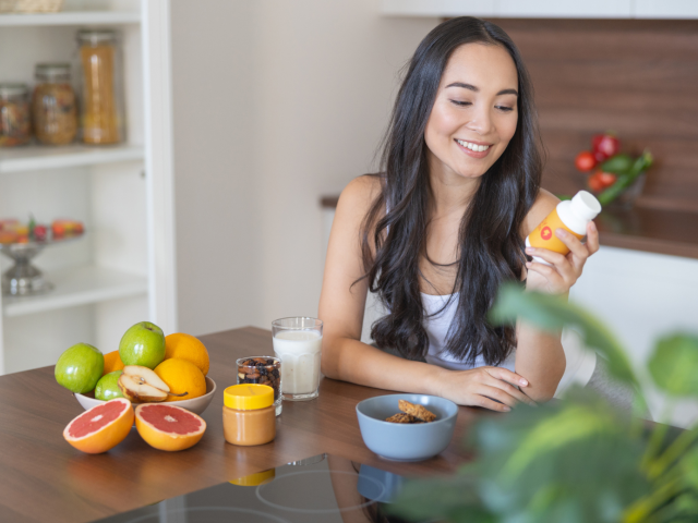 Woman holding a turmeric supplement