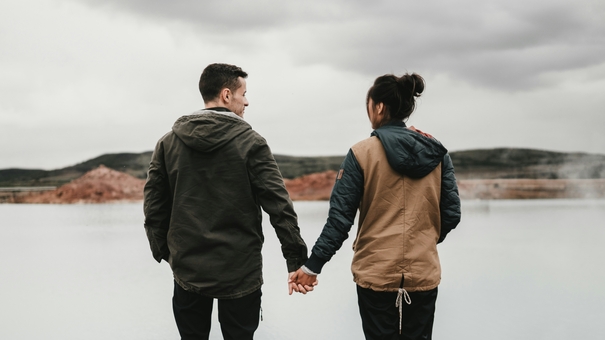 middle-aged couple holding hands by the lake - jinfiniti precision medicine